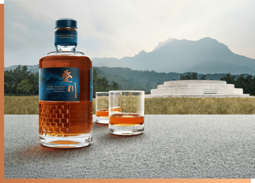 The Chuan Pure Malt Whisky bottle and glasses with mountain landscape